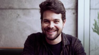 Portrait of a young man smiling at camera with red color tone. Person closeup smile
