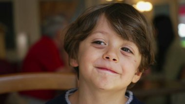 Bir yakışıklı çocuk kameraya gülümsüyor. Erkek sevimli çocuk, yakından gülümse.