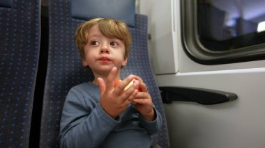 Child eating apple inside train little boy eats healthy snack