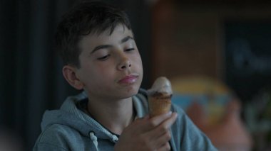 Dondurma yiyen genç bir çocuk yaz tatlısının tadını çıkarıyor.