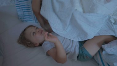 Çocuklar çarşafın altına girerler. Yorganın altında sevimli küçük kardeşler. Kardeşler hafta sonu birlikte takılıyor.