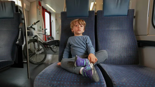 Child traveling by train seated on passenger seat