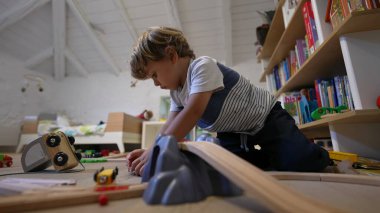 Odasında küçük bir çocuk oynuyor. Yatak odasında oynayan samimi, otantik bir çocuk. Çocukluk gelişimi