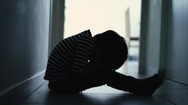 One lonely little boy sitting at home alone feeling upset unhappy child waiting for parents. Child thinking about problems suffering from bad relationship in family. Psychological trauma concept