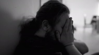 One overweight man suffering from depression at home corridor in emotional pain in monochromatic black and white