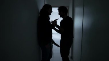 Silhouette of Man embracing woman standing in home corridor. Young Couple going through hard times. Husband and wife hugging during depression. Support concept