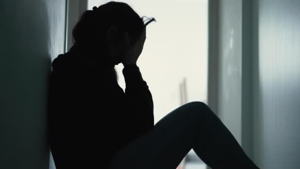 床に座っている精神疾患に苦しむ女性は 不安やうつ病を感じて顔を覆う 暗闇の中の女性のシルエット — ストック動画