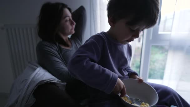 Das Kind Isst Morgens Auf Dem Schoß Der Mutter Müsli — Stockvideo