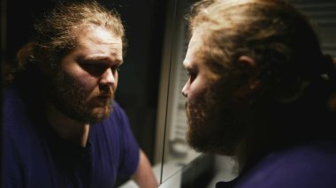 One desperate young man suffering from stress in front of mirror reflection. Person having mental pressure overwhelmed by problems and modern life