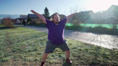One overweight young man doing jumping jacks outdoors in the cold. Back to fitness motivational discipline concept. Person exercising