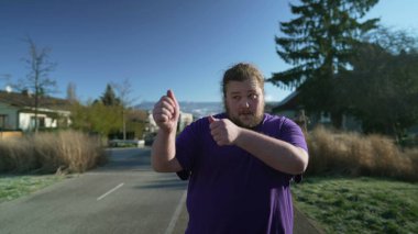 One happy fat man dancing and singing walking outside in street. A joyful overweight person celebrating life. Cheerful chubby guy