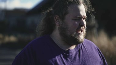 One angry young man feeling upset about past mistakes. Portrait of an overweight frustrated male person close up face in tracking shot