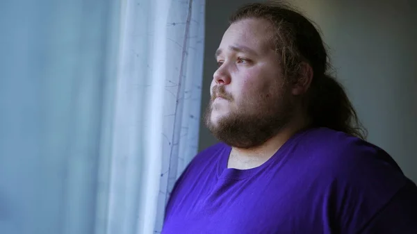 One anxious chubby man feeling worry and anxiety. Desperate person ruminating thoughts in head looking out by window