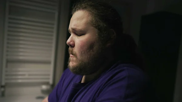 One overweight person suffering alone in front of bathroom mirror. Depression concept of a chubby man facing himself in front of mirror during hard times