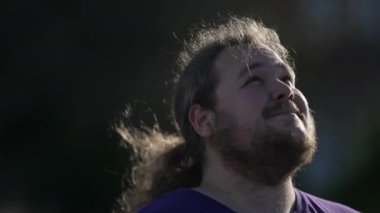 One hopeful young man closeup face looking at sky with FAITH. Tracking shot closeup of a joyful person having HOPE