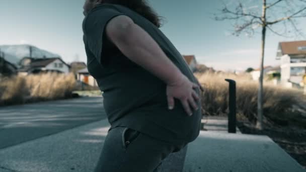 腰痛に苦しむ人の劇的な瞬間 外で怪我をしてる太りすぎの男 — ストック動画