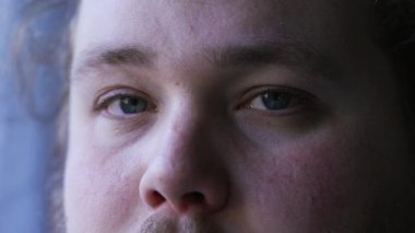 Young man close up eyes looking at camera. One caucasian casual person with natural expression macro eye