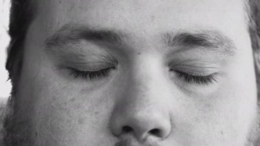 One young man smiling at camera in monochromatic black and white image. Macro eyes