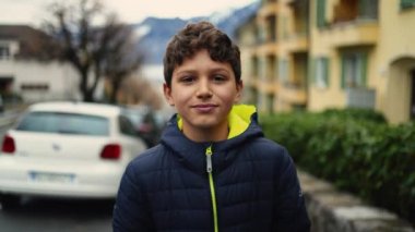 Düşünceli bir gencin portresi şehir caddesinde yürüyor. Genç çocuk Avrupa kaldırımında kameraya doğru yürüyor. Düşünceli genç çocuk.