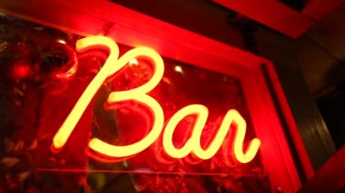 Gece giriş kapısında floresan lambası akıyor. Red Bar reklamcılık işi karanlıkta parlıyor.