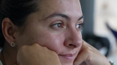 Düşünceli bir kadın gözyaşı dolu duygularla yüzünü kapatıyor. 30 'lu yaşlarda düşünceli bir kadın elleri çenesinde düşünceli bir ifadeyle.