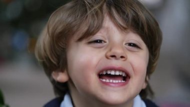 One cute small boy portrait face closeup smiling and laughing