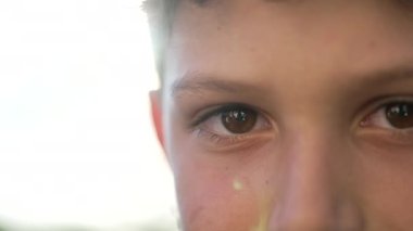 Close up of a child closing eyes in contemplation. One meditative male kid boy closes eye. Macro closeup