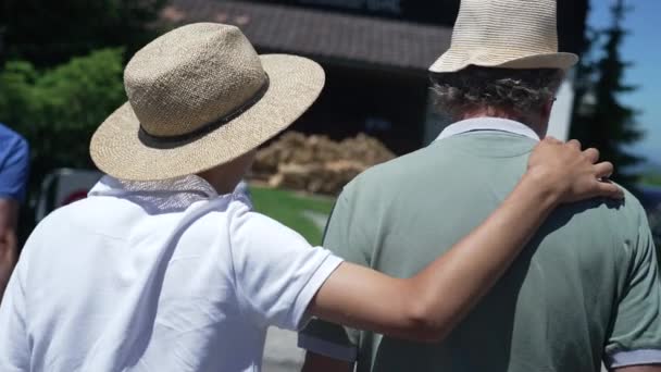Back Son Embracing Father Arm Walking Together Wearing Panama Hats — Stok video