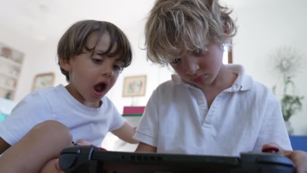 Δύο Μικρά Αγόρια Που Κοιτάζουν Την Ταμπλέτα Οθόνης Βιντεοπαιχνιδιών Μικρότερος — Αρχείο Βίντεο