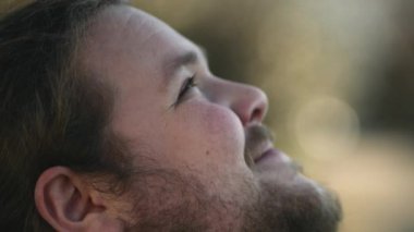 Close up face of a spiritual happy man looking at sky with HOPE. Faithful casual person