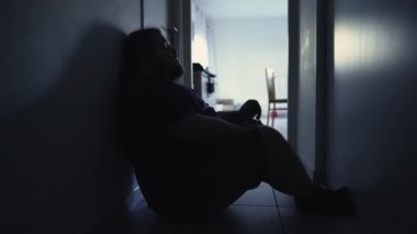 Silhouette of Lonely person suffering from mental illness sitting in corridor. Depressive man in despair