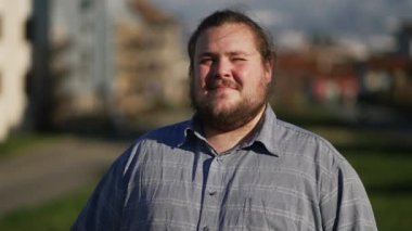 One hopeful overweight man standing outdoors in looking up at sky with GRATITUDE