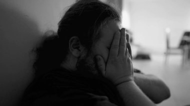 One overweight man suffering from depression at home corridor in emotional pain in monochromatic black and white