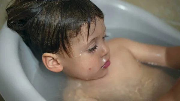 Small boy inside bath tub. Closeup baby tdodler bathing in bathtub washing body hygiene infant routine
