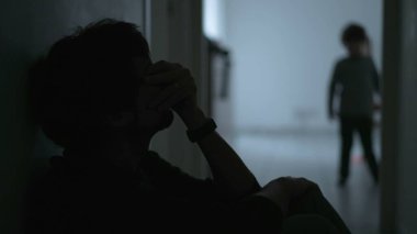 Son hugging father during crisis. Child consoling dad in difficult times. Depressed father suffering from financial problems. Kid hugging dad