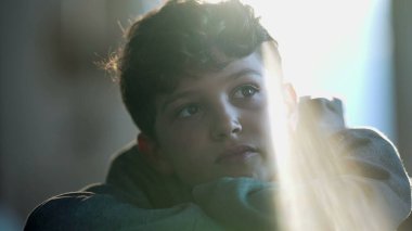 Thoughtful child with dreamy expression thinking about life. One pensive kid in contemplation and daydreaming