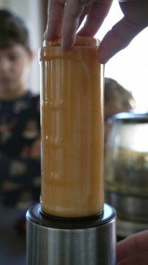 Fruit juicer blending fruits for morning breakfast. Nutritious healthy food. Blender close up in Vertical Video