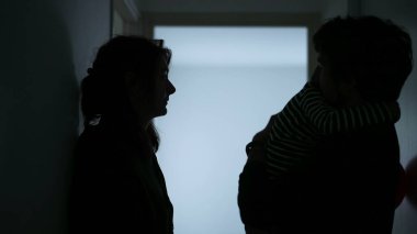 Young parents Arguing and Fighting. Domestic Violence and Emotional abuse Scene. Stressed man and aggressive Man yelling at wife at Dark Hallway of Apartment. Making peace with child