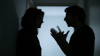 Young parents Arguing and Fighting. Domestic Violence and Emotional abuse Scene. Stressed man and aggressive Man yelling at wife at Dark Hallway of Apartment. Making peace with child