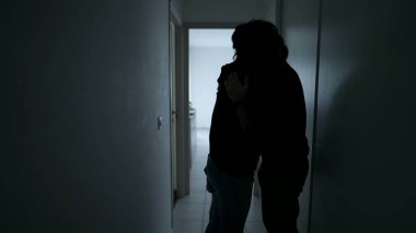 Silhouette of Man embracing woman standing in home corridor. Young Couple going through hard times. Husband and wife hugging during depression. Support and counseling concept