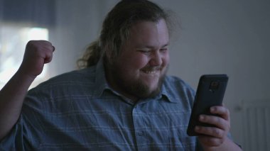 One excited fat man celebrates success in front of computer. close up male person face feeling happy. WOW winner emotion