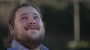 Hopeful young man looking at sky with FAITH. Happy casual male person in 20s feeling gratitude and the presence of GOD