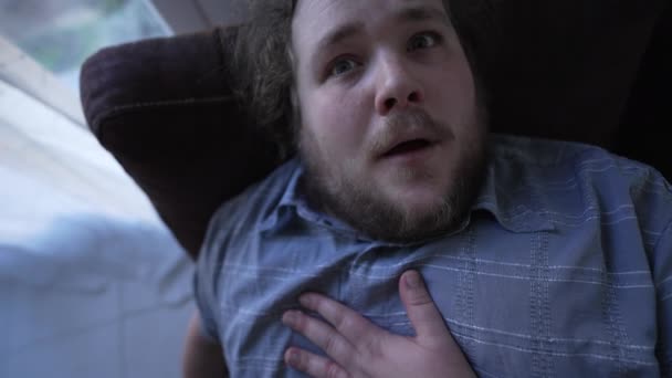 体重增加的男人胸痛 一个患心脏病的胖子躺在沙发上 男性忧郁症患者的近视 — 图库视频影像
