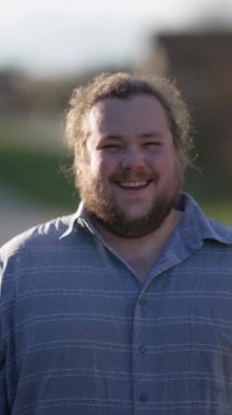 One overweight young happy man real life laugh and smile. Portrait of a casual male caucasian person laughing outdoors in sunlight