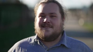 Close up face of a positive young man walking with confidence outside in nature