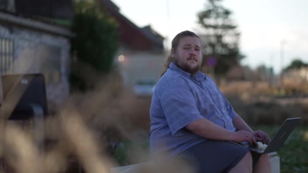 Ein Freiberuflicher Junger Mann Sitzt Draußen Einer Bank Mit Laptop — Stockvideo