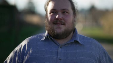 Close up face of a positive young man walking with confidence outside in nature