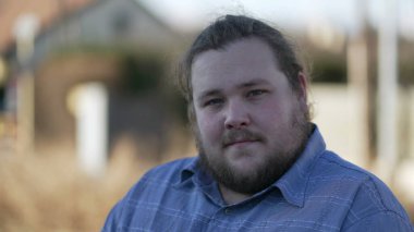 Portrait of a young chubby man close up face smiling at camera in tracking shot in movement. Happy male caucasian person in 20s