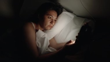 Cep telefonunu kapatan bir kadın gece yatağında yatıyor. Akşamları parlayan ışığı kapatan kişi