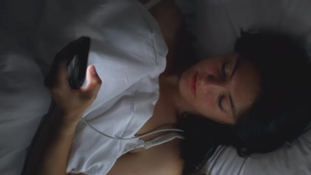 Frau Liegt Nachts Bett Und Schaut Auf Telefonbildschirm — Stockvideo
